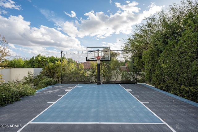 view of basketball court featuring basketball hoop and fence