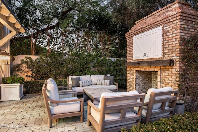 view of patio featuring an outdoor living space with a fireplace and fence