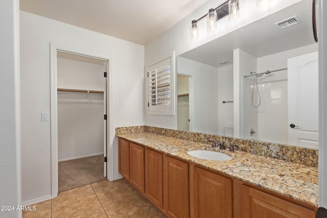 bathroom with vanity, walk in shower, and tile patterned floors