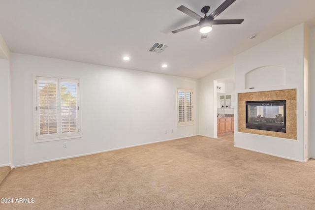 unfurnished living room featuring light colored carpet, plenty of natural light, and ceiling fan