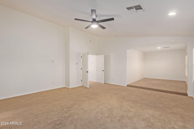 carpeted empty room featuring ceiling fan and vaulted ceiling