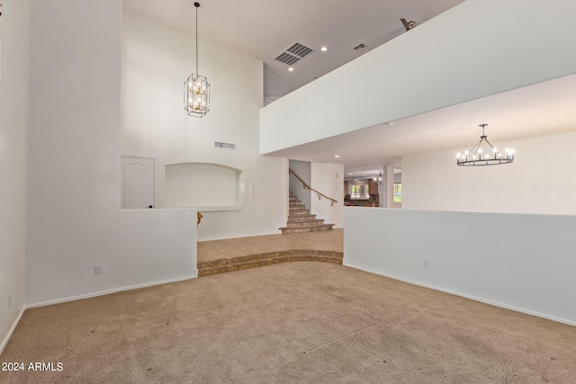 unfurnished living room featuring carpet and a high ceiling