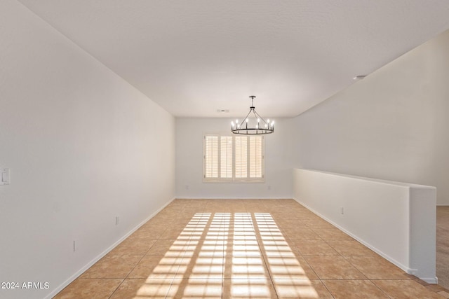 unfurnished dining area featuring light tile patterned flooring and a chandelier