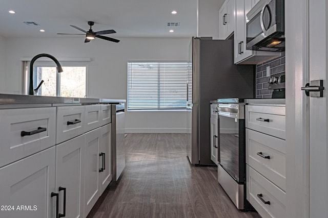 kitchen featuring backsplash, white cabinetry, ceiling fan, stainless steel appliances, and dark hardwood / wood-style floors