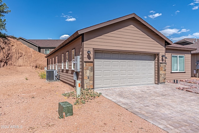 view of front of house with central AC and a garage