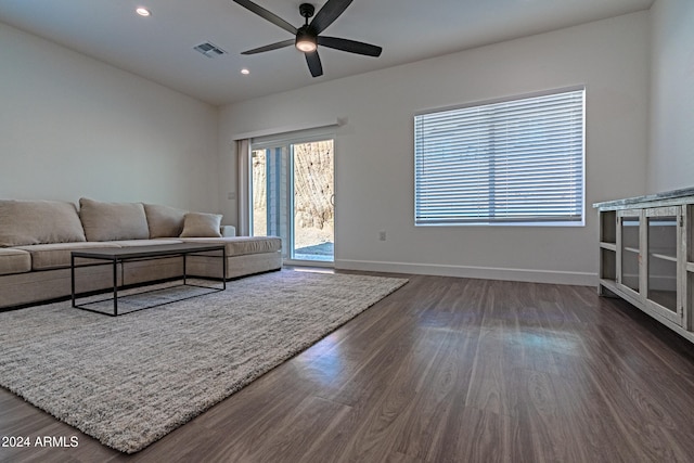 living room featuring ceiling fan and dark hardwood / wood-style floors