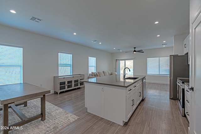 kitchen featuring appliances with stainless steel finishes, white cabinets, a healthy amount of sunlight, and sink