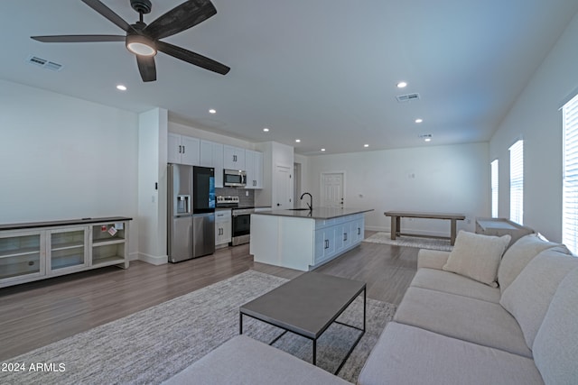 living room featuring light hardwood / wood-style floors and ceiling fan