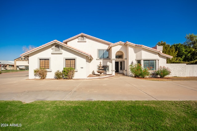 mediterranean / spanish home with a front yard and a patio area