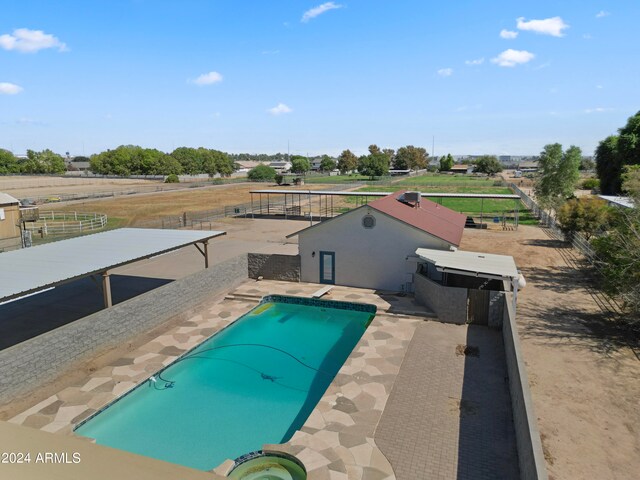 view of swimming pool featuring a jacuzzi and a patio