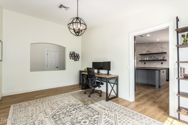 office space with an inviting chandelier and light hardwood / wood-style flooring