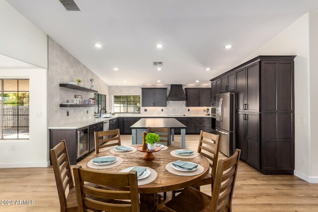 dining room with plenty of natural light, sink, and light hardwood / wood-style flooring