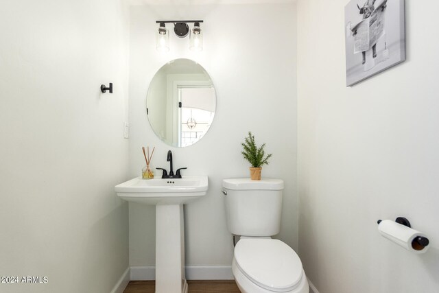 bathroom featuring hardwood / wood-style flooring and toilet