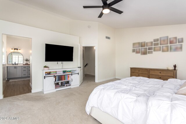 bedroom with lofted ceiling, ceiling fan, sink, connected bathroom, and light colored carpet