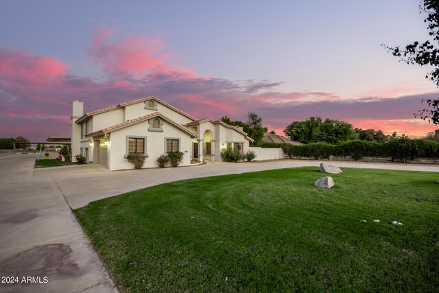 mediterranean / spanish home featuring a garage and a yard