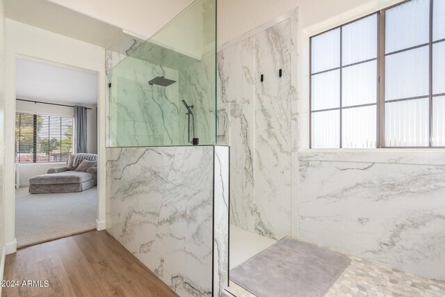 bathroom with hardwood / wood-style flooring and tiled shower