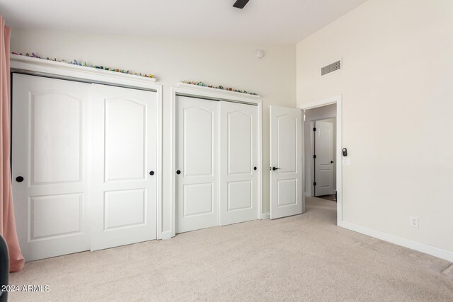 unfurnished bedroom featuring light carpet and high vaulted ceiling