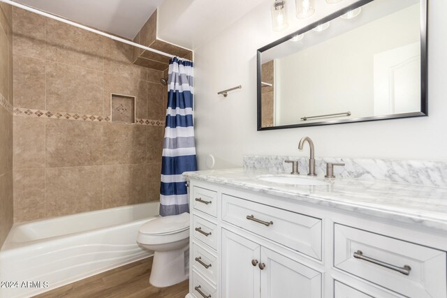 full bathroom with vanity, hardwood / wood-style flooring, shower / bath combo with shower curtain, and toilet