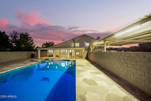 pool at dusk with a patio