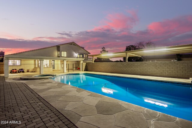 pool at dusk with a patio