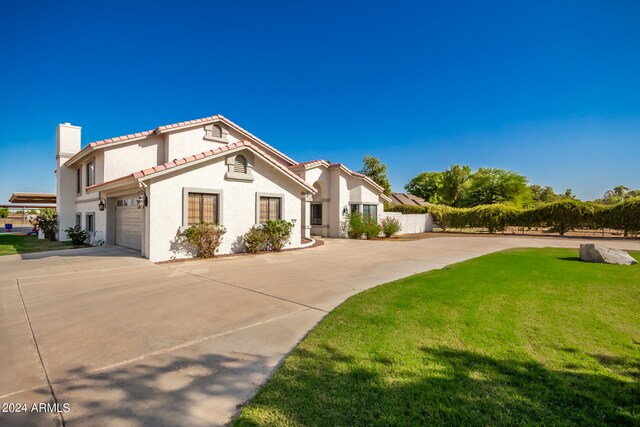 mediterranean / spanish-style home with a front yard and a garage