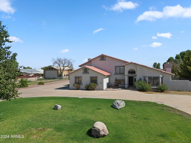 mediterranean / spanish home with a front lawn