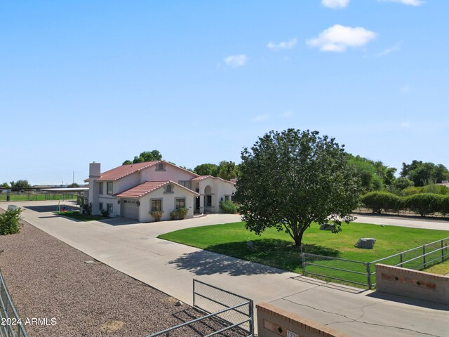 mediterranean / spanish home with a garage and a front lawn