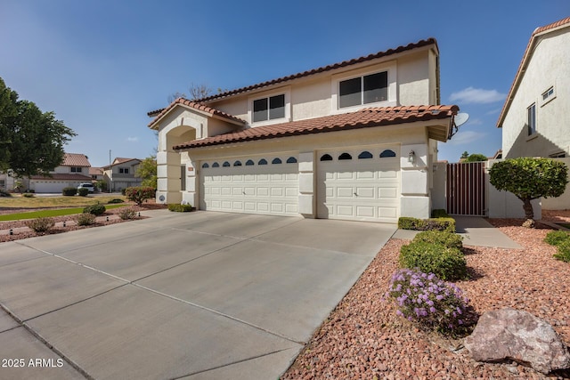 mediterranean / spanish-style home with driveway, a tiled roof, and stucco siding