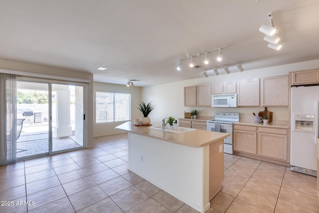 kitchen with light brown cabinets, white appliances, light tile patterned floors, and a sink