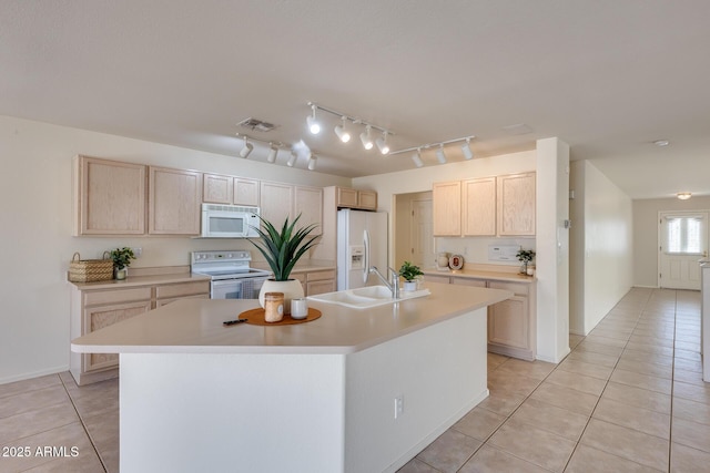 kitchen with light brown cabinets, white appliances, light tile patterned floors, and a sink