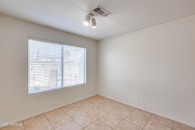 spare room with light tile patterned floors, baseboards, and visible vents