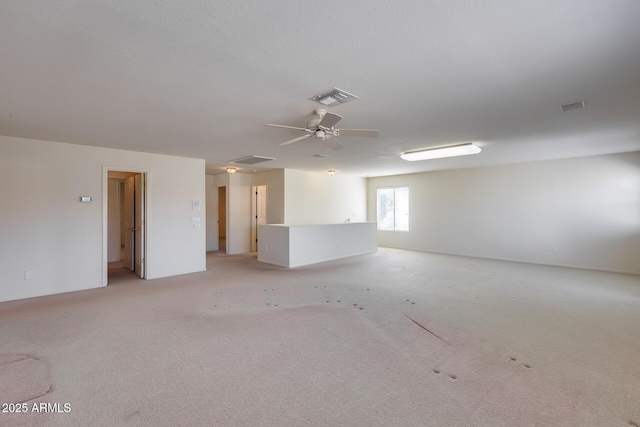 spare room with ceiling fan, visible vents, and light colored carpet