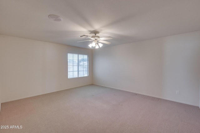 empty room with a ceiling fan, light colored carpet, and baseboards