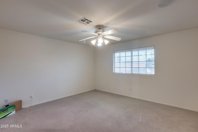 empty room with a ceiling fan, visible vents, light carpet, and baseboards