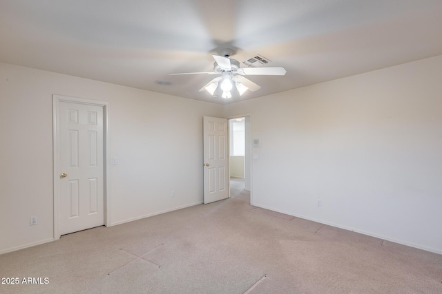 empty room featuring a ceiling fan, light carpet, visible vents, and baseboards