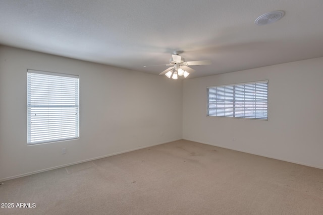 unfurnished room with visible vents, ceiling fan, and light carpet