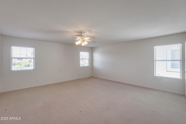 empty room with ceiling fan, baseboards, and light colored carpet