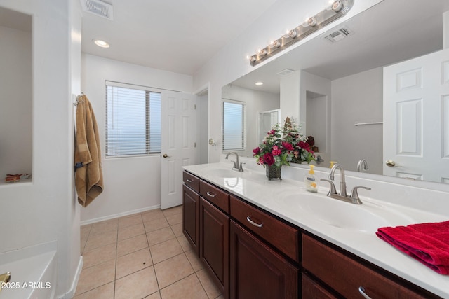 bathroom featuring a shower with door, vanity, and tile patterned floors