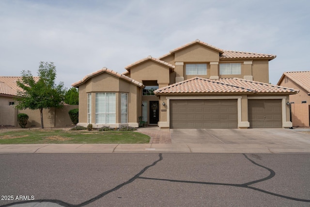 mediterranean / spanish home featuring fence, stucco siding, a tiled roof, concrete driveway, and an attached garage