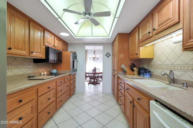 kitchen featuring ceiling fan with notable chandelier, sink, light tile patterned floors, black appliances, and light stone countertops