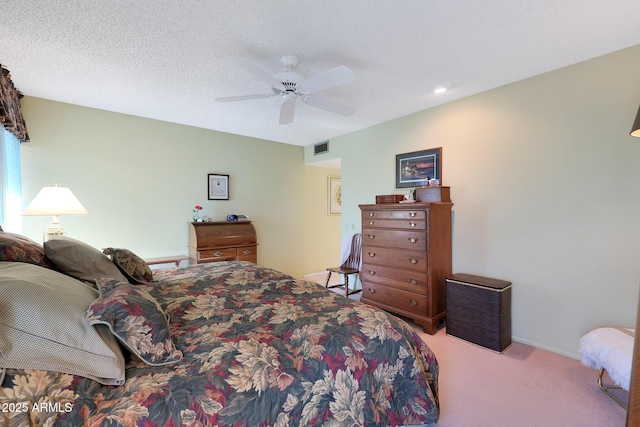 bedroom featuring ceiling fan, light colored carpet, and a textured ceiling