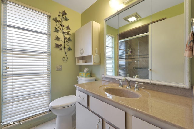 bathroom featuring tile patterned flooring, vanity, walk in shower, and toilet