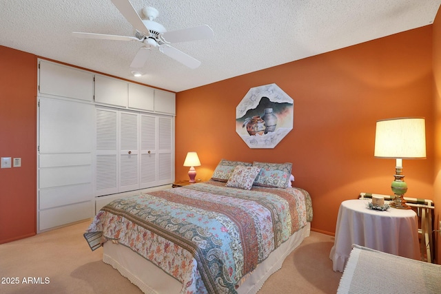 carpeted bedroom featuring ceiling fan, a closet, and a textured ceiling