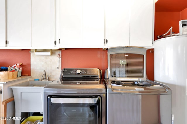 clothes washing area featuring separate washer and dryer, sink, water heater, and cabinets