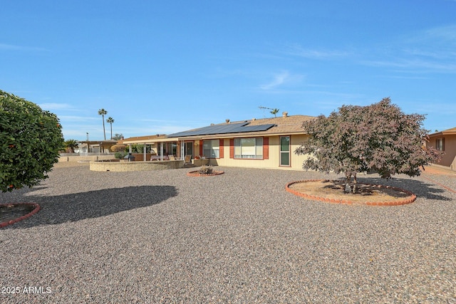 rear view of house featuring solar panels