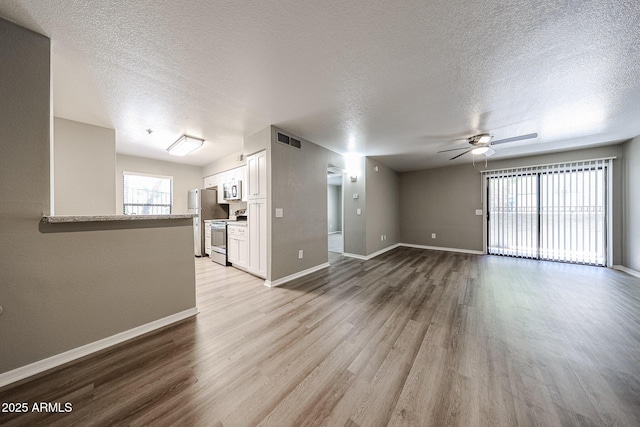 2025 E Campbell Ave Unit 137, Phoenix, AZ 85016 - unfurnished living room with a textured ceiling, ceiling fan, and light wood finished floors