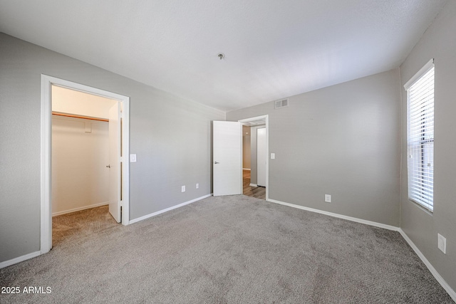 2025 E Campbell Ave Unit 137, Phoenix, AZ 85016 - unfurnished bedroom with a spacious closet, multiple windows, and carpet floors