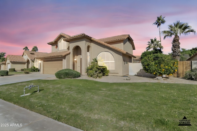 mediterranean / spanish house with a garage and a yard