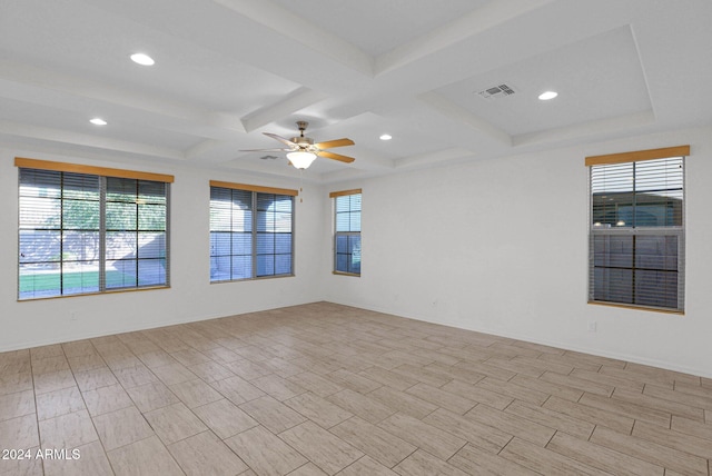 spare room featuring a wealth of natural light, ceiling fan, beam ceiling, and coffered ceiling