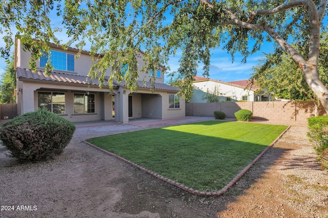 back of house with a patio area and a lawn